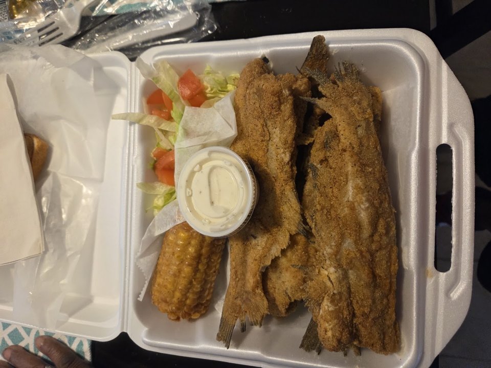 Crisp hush puppies beside a seafood entree.